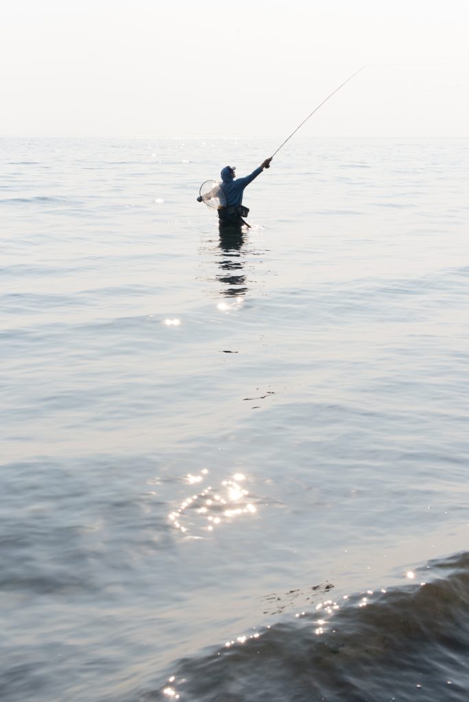 An angler makes a backcast while flyfishing in the Puget Sound.