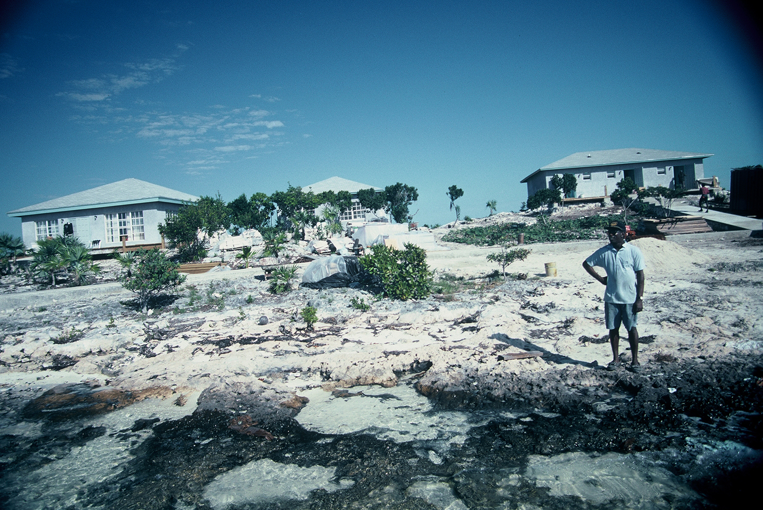 A man standing on the shore in front of a bahamian flyfishing lodge