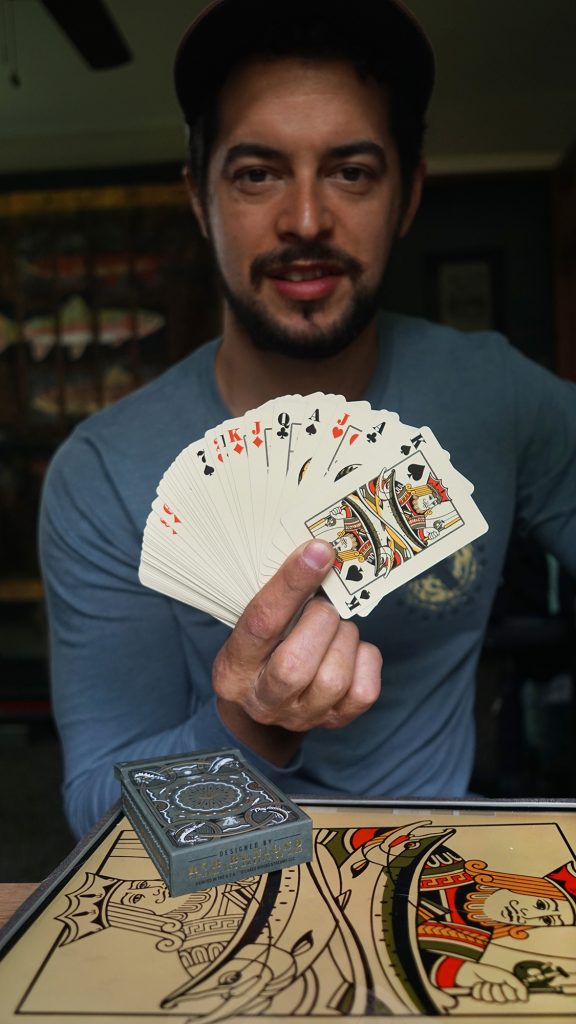 A man holding a fanned deck of custom playing cards